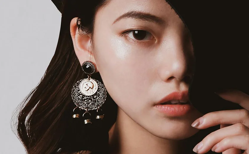 Asian model with earings covering face